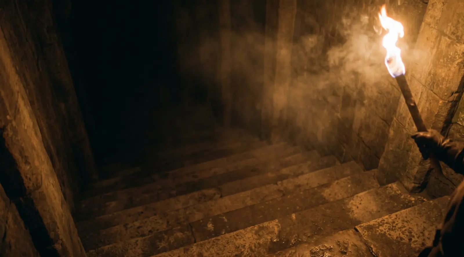 A torch lighting an ancient stone stairway falling away into darkness